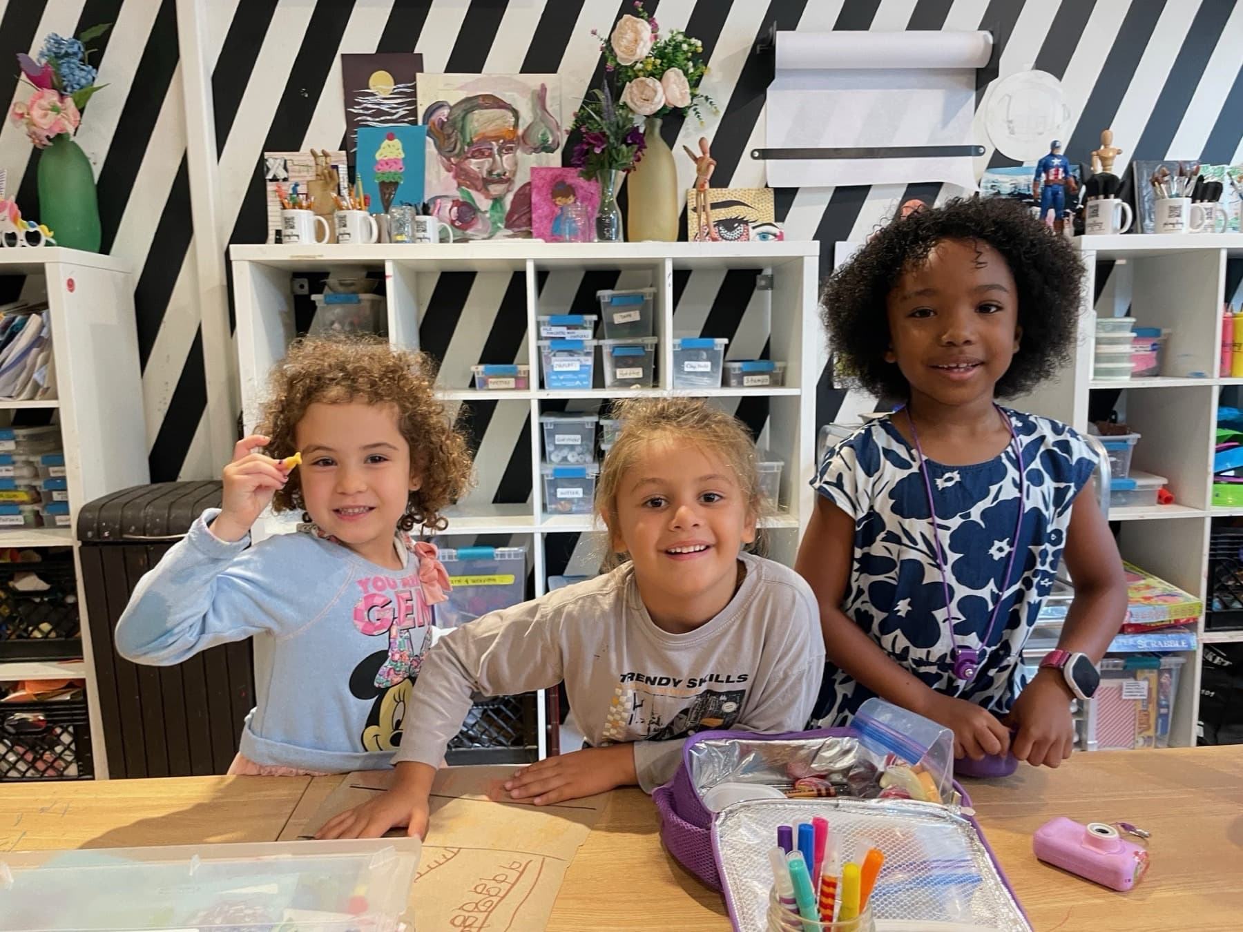 Three children smiling at the camera in a PLAYDAY studio