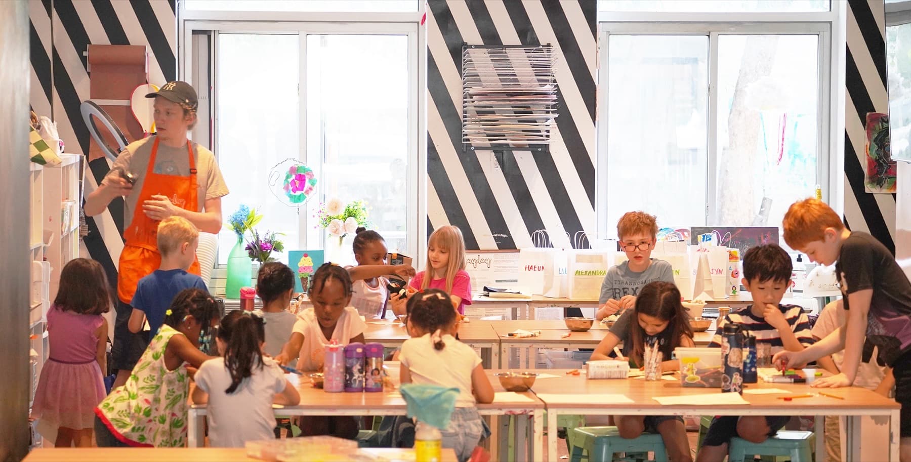 A PLAYDAY studio full of children making art at the tables