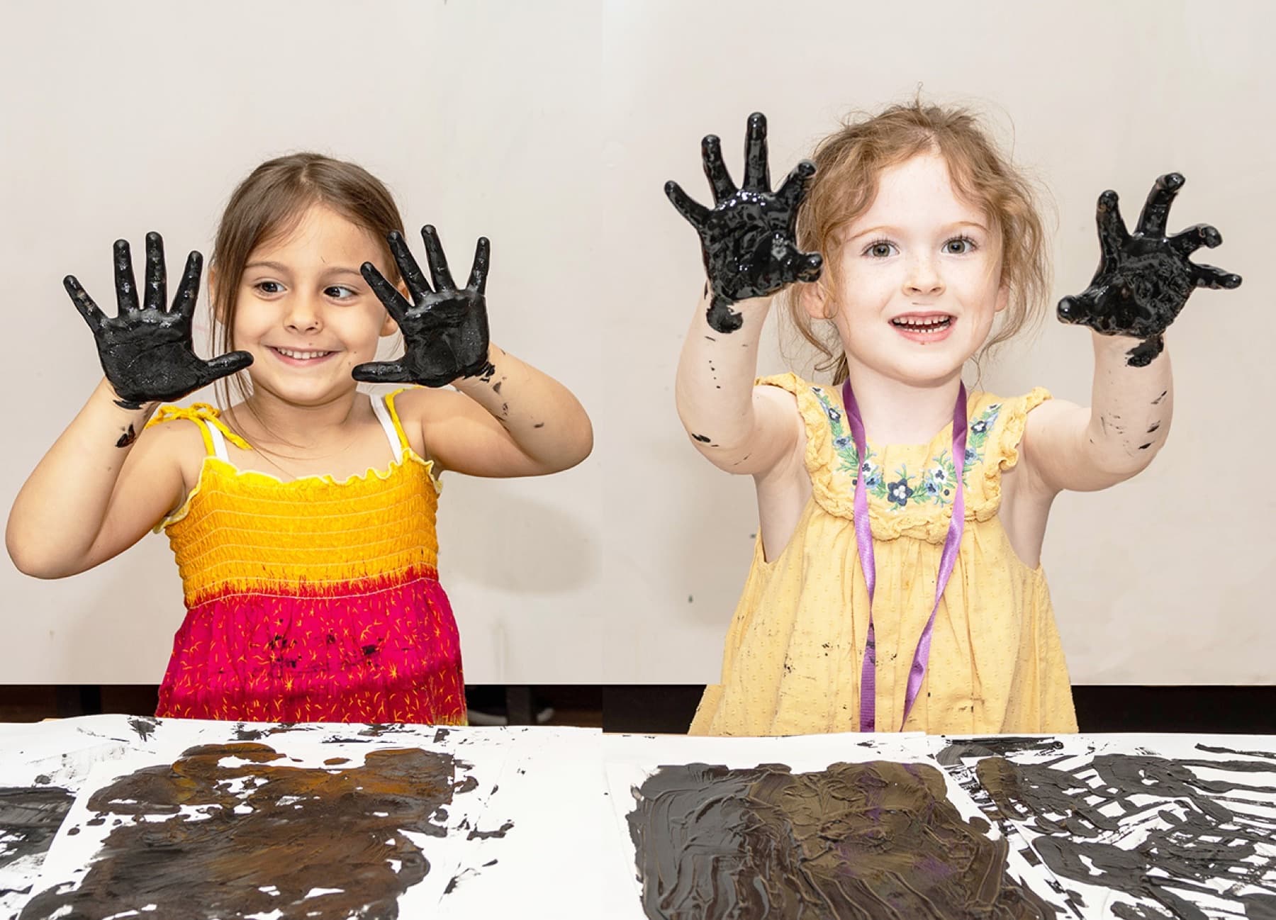 Two children showing off paint covered hands at PLAYDAY